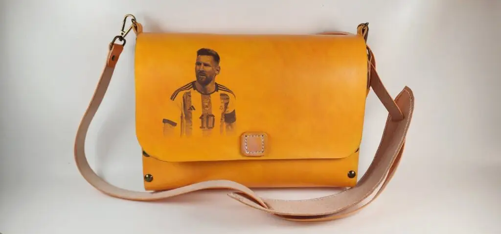 El bolso de cuero vegetal destaca por su diseño único y su confección artesanal. La imagen de Messi, cuidadosamente grabada en el cuero, le otorga un toque distintivo y personal. Este bolso no solo es un accesorio de moda, sino también una pieza de colección para los admiradores del legendario futbolista. Su capacidad y estructura lo hacen perfecto para el uso diario, combinando funcionalidad y estilo.